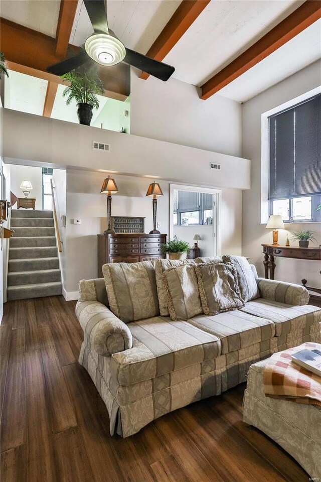 living room featuring dark hardwood / wood-style flooring, beam ceiling, and ceiling fan