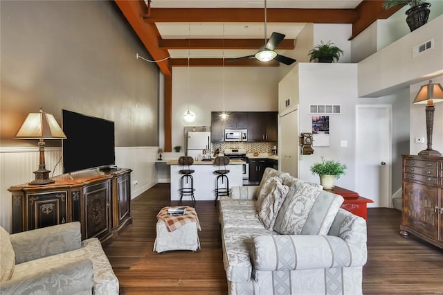 living room featuring dark wood-type flooring, beamed ceiling, high vaulted ceiling, and ceiling fan