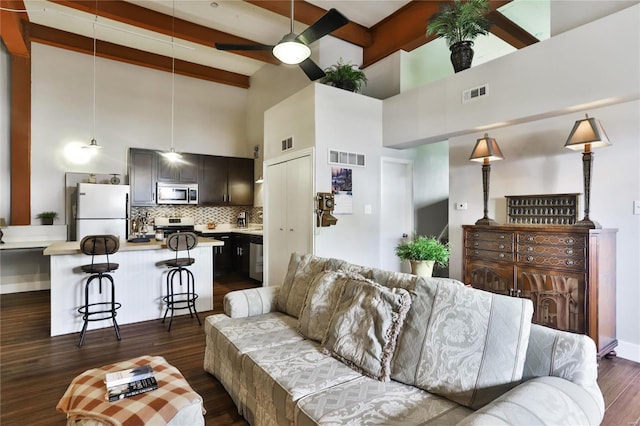 living room with beamed ceiling, dark hardwood / wood-style flooring, ceiling fan, and high vaulted ceiling