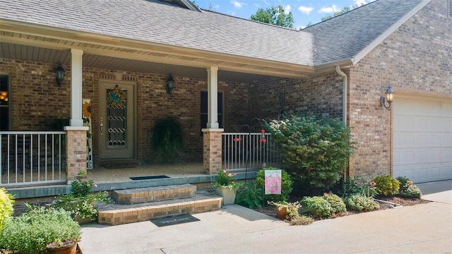 entrance to property with covered porch, brick siding, roof with shingles, and a garage