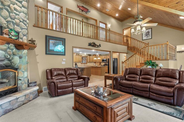 living room featuring a stone fireplace, light colored carpet, high vaulted ceiling, wooden ceiling, and ceiling fan