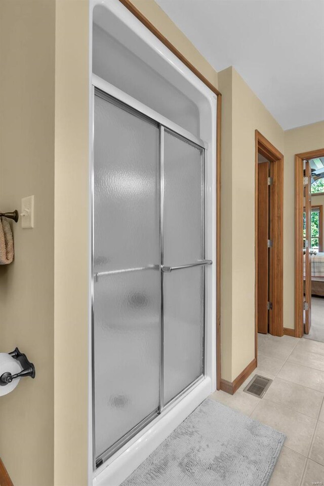 bathroom featuring tile patterned flooring and an enclosed shower