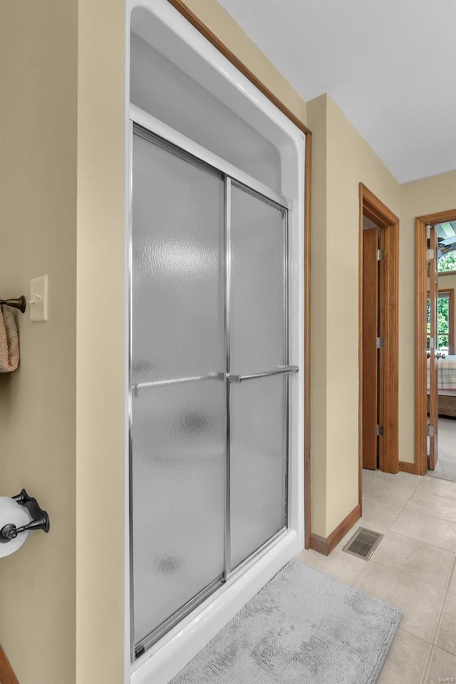 bathroom featuring tile patterned flooring, a shower stall, visible vents, and baseboards