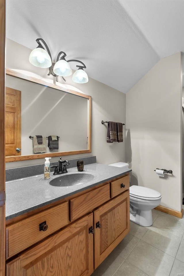 bathroom featuring vaulted ceiling, vanity, toilet, and tile patterned floors