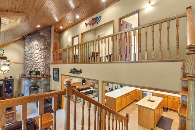 staircase with wood ceiling, tile patterned floors, a fireplace, high vaulted ceiling, and recessed lighting