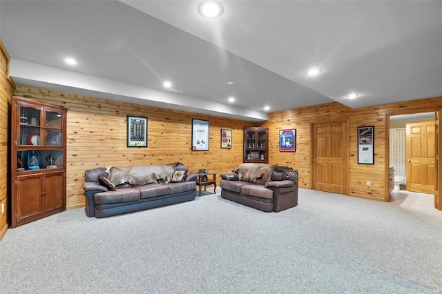 living room featuring carpet floors and wood walls