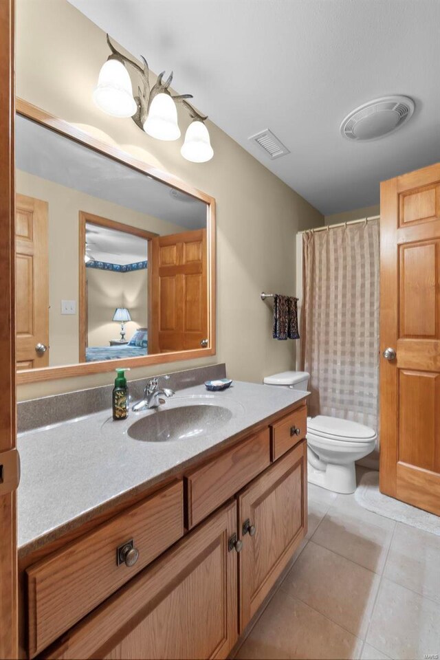 bathroom featuring vanity, tile patterned flooring, and toilet