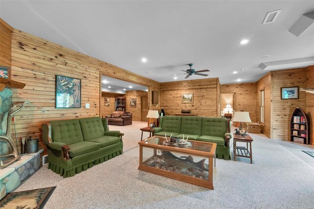 living room featuring carpet, wooden walls, and ceiling fan