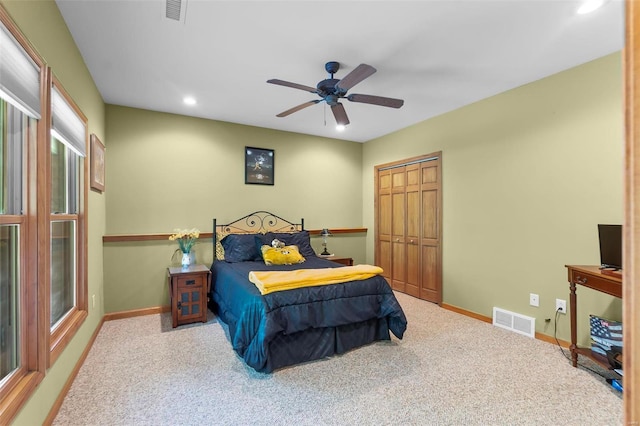 carpeted bedroom featuring a closet and ceiling fan