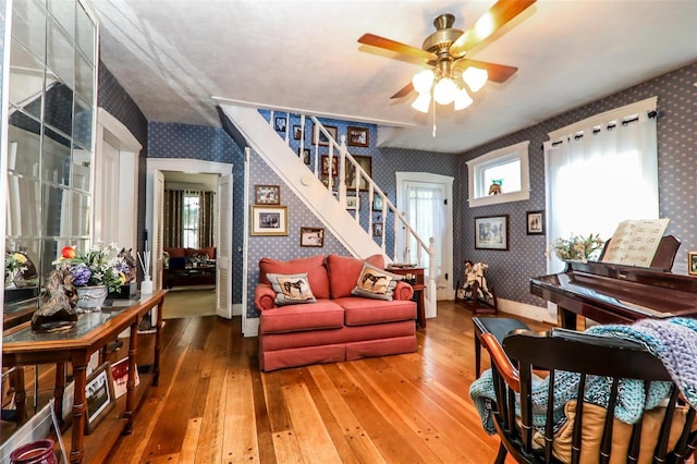 living area with wood-type flooring and ceiling fan