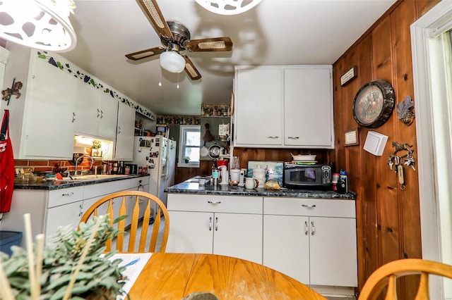 kitchen featuring sink, white refrigerator with ice dispenser, white cabinets, and ceiling fan