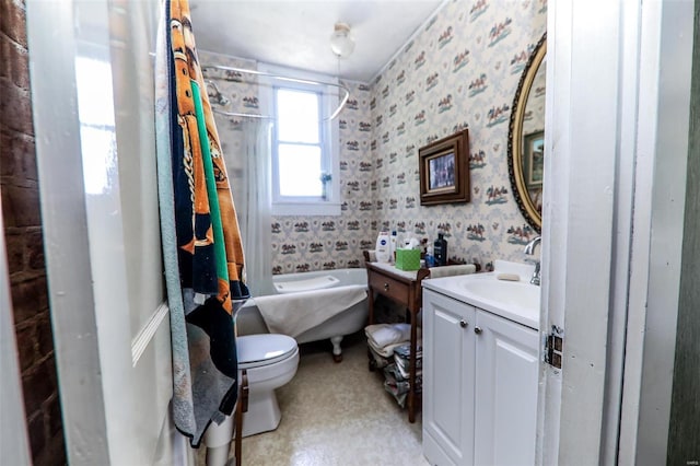 bathroom with toilet, vanity, and a bath