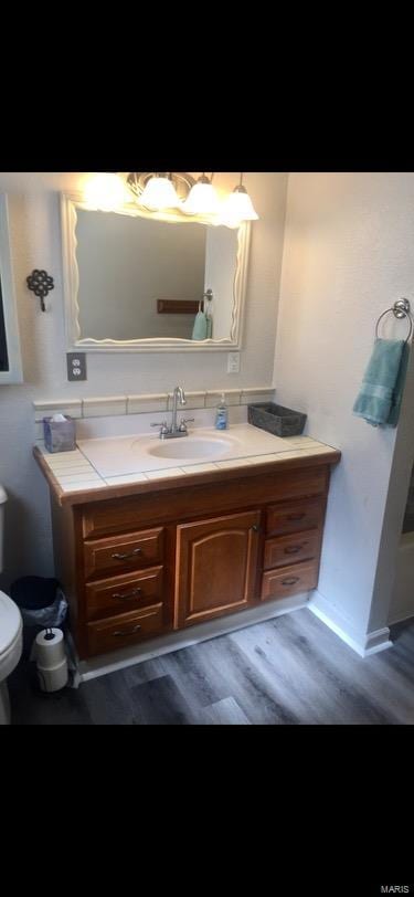 bathroom featuring vanity, toilet, and hardwood / wood-style flooring