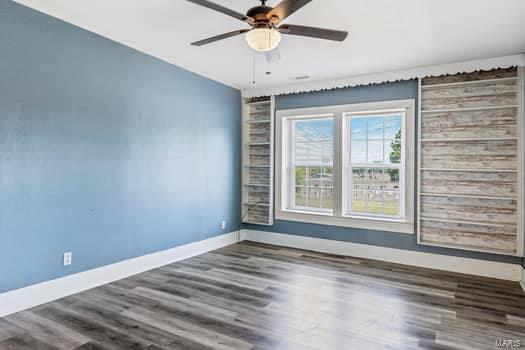 spare room featuring dark hardwood / wood-style floors and ceiling fan