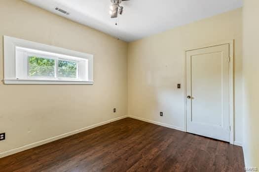 empty room featuring dark wood-type flooring and ceiling fan