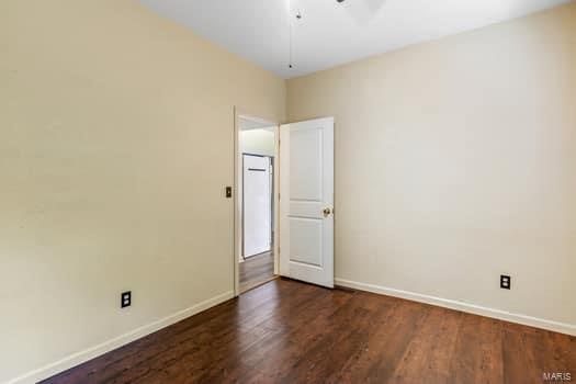 spare room featuring dark wood-type flooring and ceiling fan