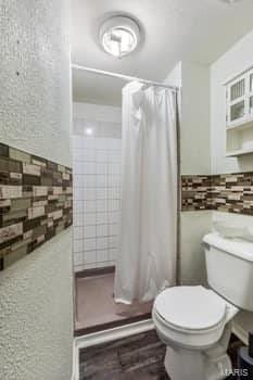 bathroom featuring toilet and a shower with shower curtain