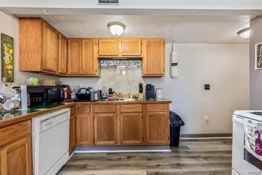 kitchen featuring sink, white appliances, and dark hardwood / wood-style flooring