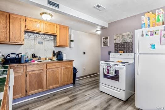 kitchen with hardwood / wood-style flooring, sink, and white appliances