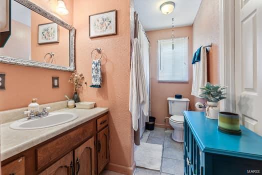 bathroom featuring toilet, vanity, and tile patterned flooring