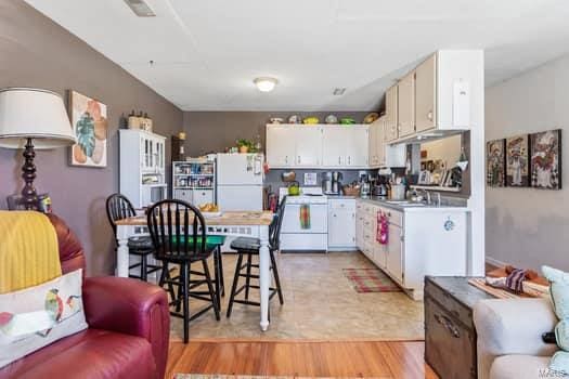 kitchen featuring light hardwood / wood-style flooring, white cabinetry, and white stove