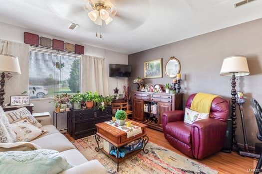 living room featuring light wood-type flooring and ceiling fan