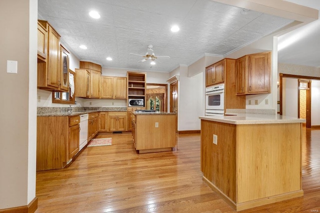 kitchen with kitchen peninsula, light wood-type flooring, white appliances, and a center island