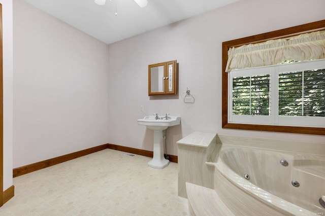 bathroom with a tub to relax in and sink