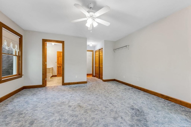 unfurnished bedroom featuring light carpet, ceiling fan, and connected bathroom