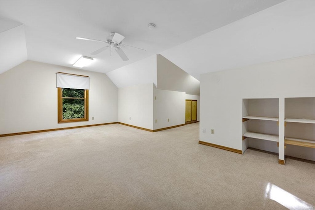 additional living space with ceiling fan, light colored carpet, and vaulted ceiling