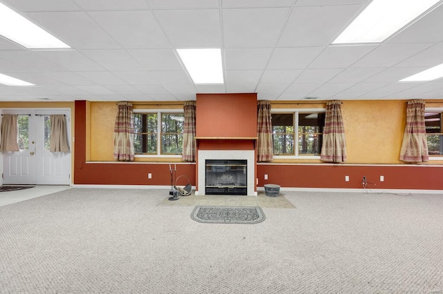 carpeted living room with a healthy amount of sunlight and a drop ceiling