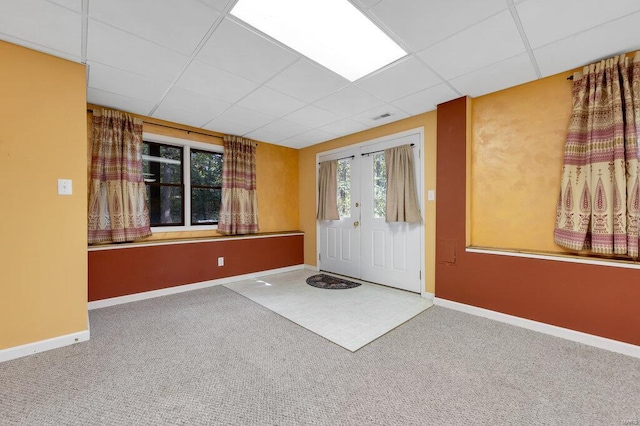 carpeted foyer entrance featuring a paneled ceiling