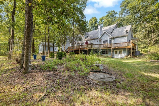 rear view of property with a deck and a lawn