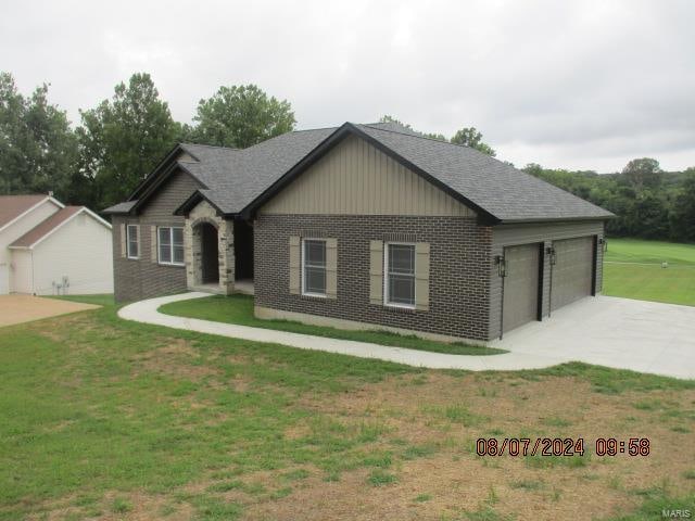 view of front of property featuring a garage and a front lawn