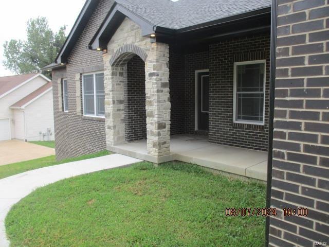 doorway to property featuring a garage and a yard