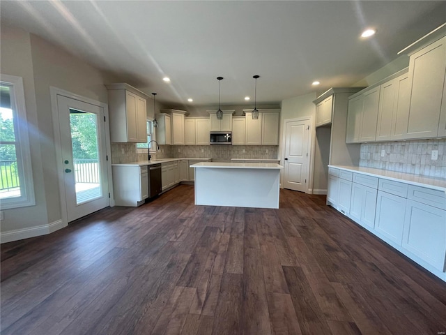 kitchen featuring dark hardwood / wood-style floors, tasteful backsplash, a kitchen island, stainless steel appliances, and pendant lighting