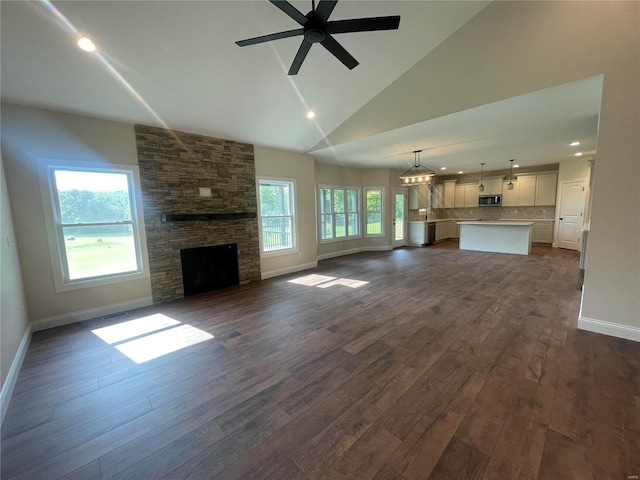 unfurnished living room featuring a fireplace, ceiling fan, hardwood / wood-style flooring, and a wealth of natural light