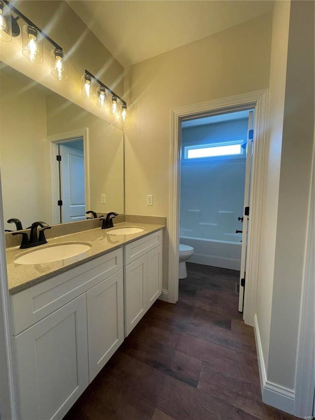 full bathroom featuring hardwood / wood-style flooring, double vanity, shower / bathtub combination, and toilet