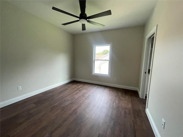 spare room featuring ceiling fan and dark wood-type flooring