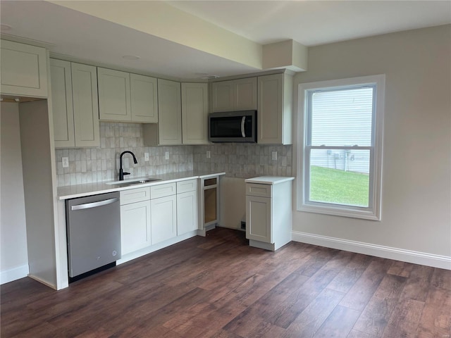 kitchen with sink, backsplash, dark wood-type flooring, and stainless steel appliances