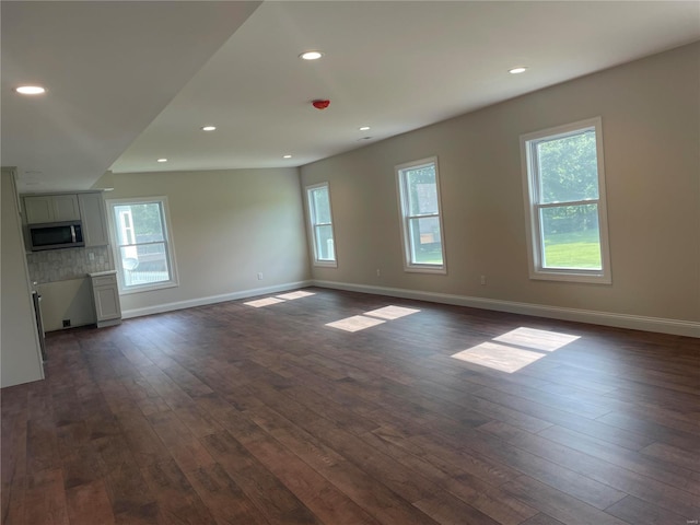 unfurnished living room with dark wood-type flooring