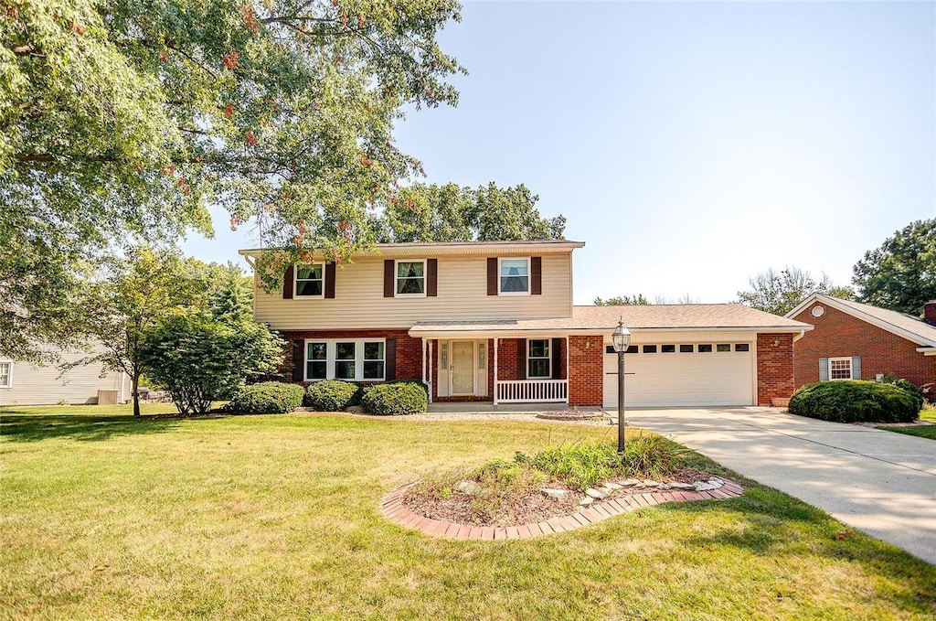 front of property featuring a garage, a front lawn, and covered porch