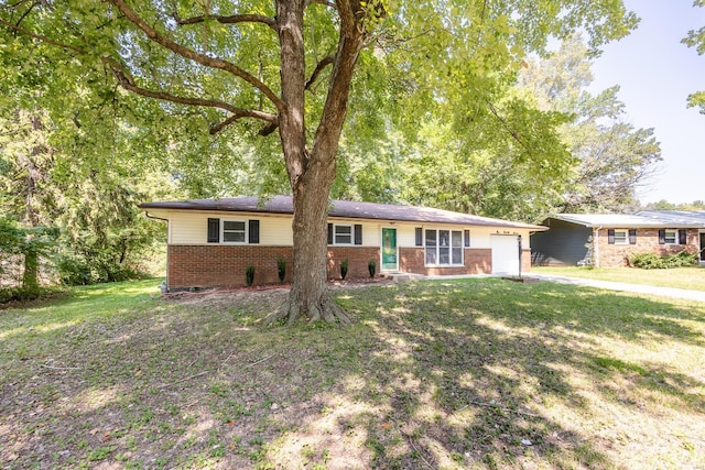 ranch-style house featuring a garage, brick siding, and a front yard