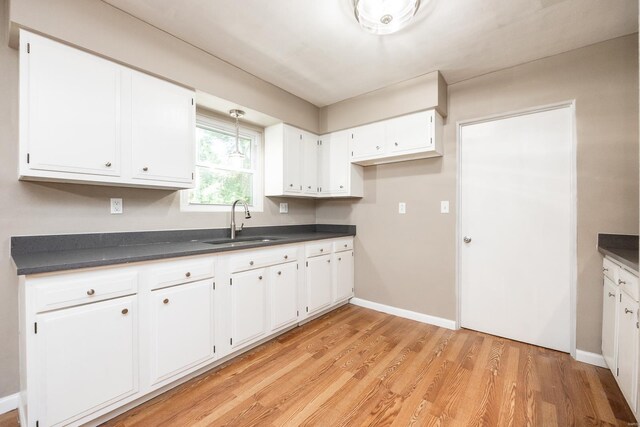 kitchen with sink, white cabinets, and light hardwood / wood-style floors