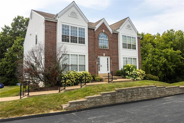 view of front facade with a front lawn and brick siding