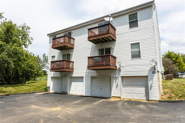 rear view of property featuring a balcony, a garage, and central air condition unit