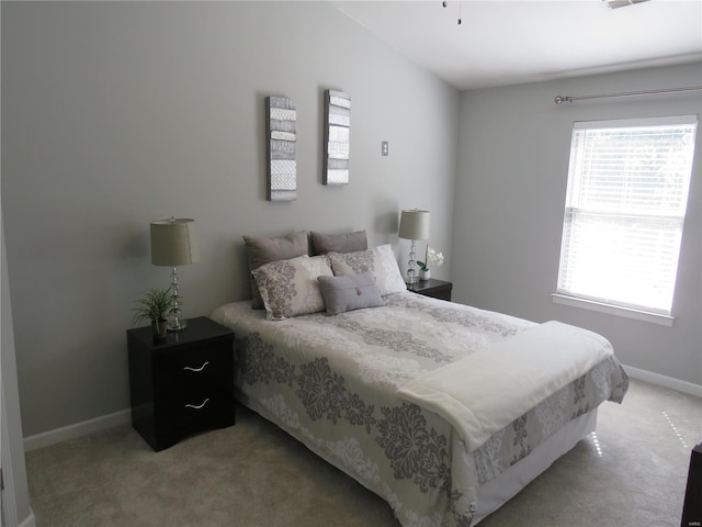 bedroom featuring baseboards and light colored carpet