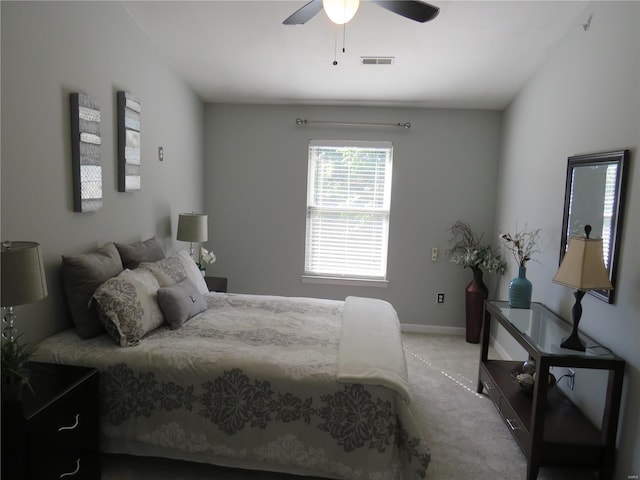 bedroom featuring light carpet, baseboards, visible vents, and a ceiling fan