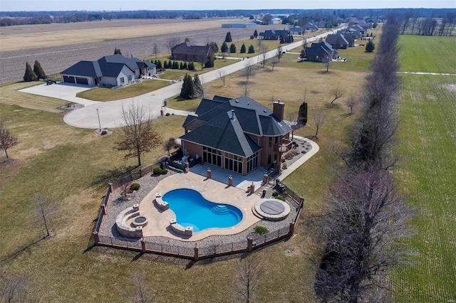 view of swimming pool featuring a patio, a rural view, a fire pit, and a fenced backyard