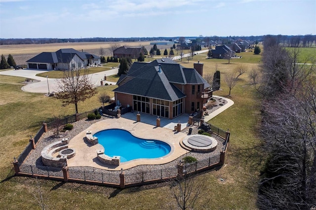 view of pool featuring a patio, a sunroom, a fenced backyard, and an outdoor fire pit